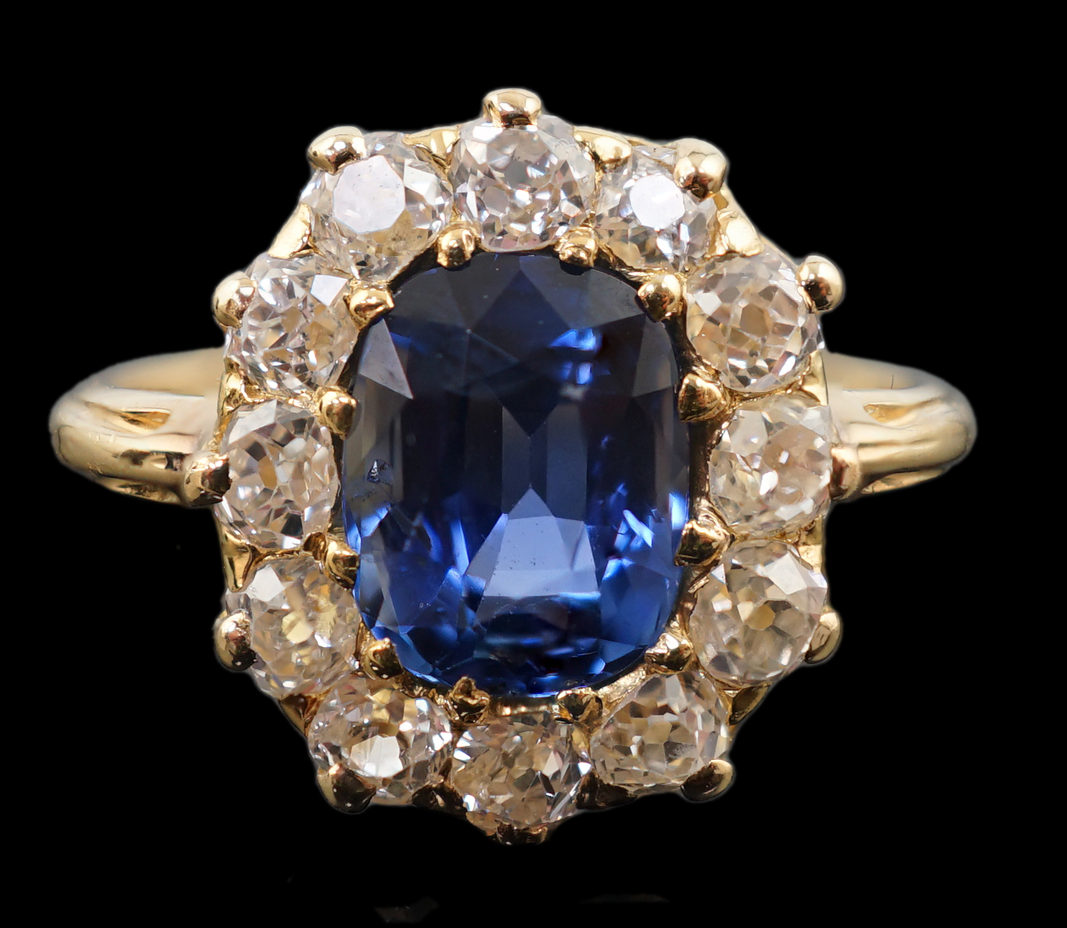 A gold, sapphire and old round cut diamond set oval cluster ring